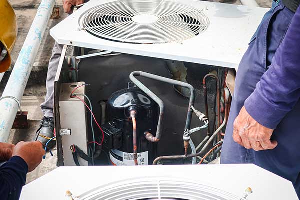 an open AC unit being inspected for repair