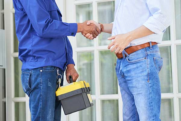 HVAC technician shaking hands with customer after completing HVAC repairs